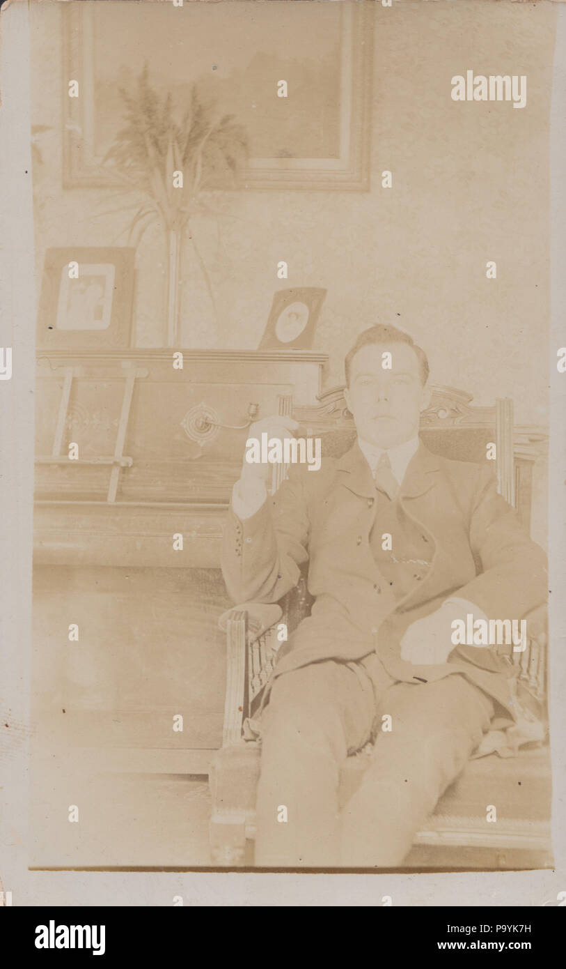 Vintage Foto von einem Gentleman Entspannende und setzte sich neben einem Klavier Stockfoto