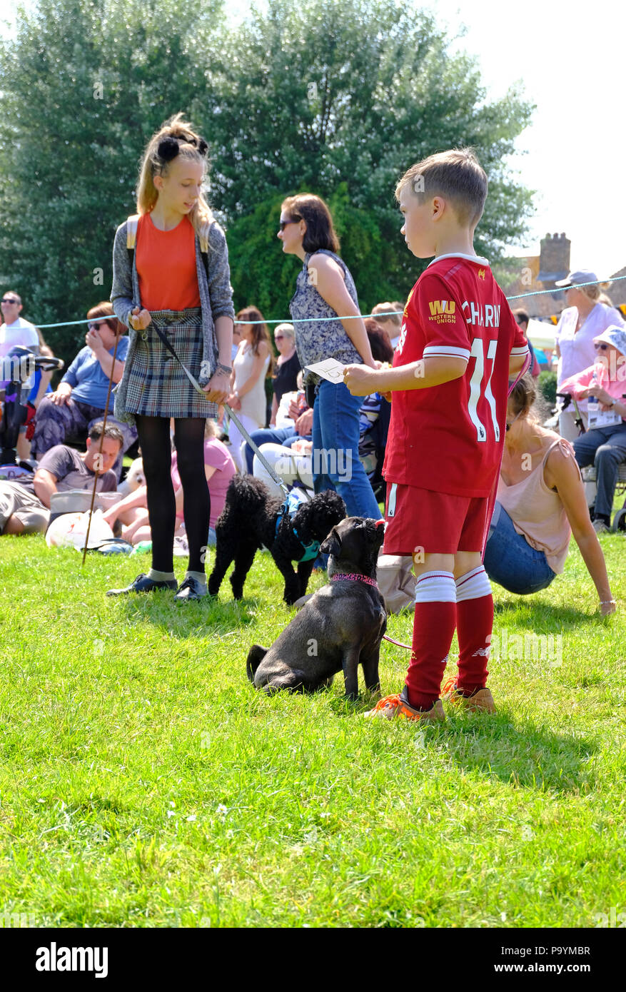 East Preston, West Sussex, UK. Fun Dog Show am Dorfplatz - Kinder in der Schlange ihre Hunde zu zeigen Stockfoto