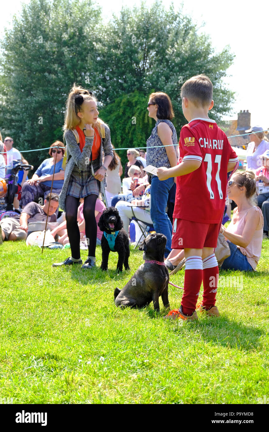 East Preston, West Sussex, UK. Fun Dog Show am Dorfplatz - Kinder in der Schlange ihre Hunde zu zeigen Stockfoto