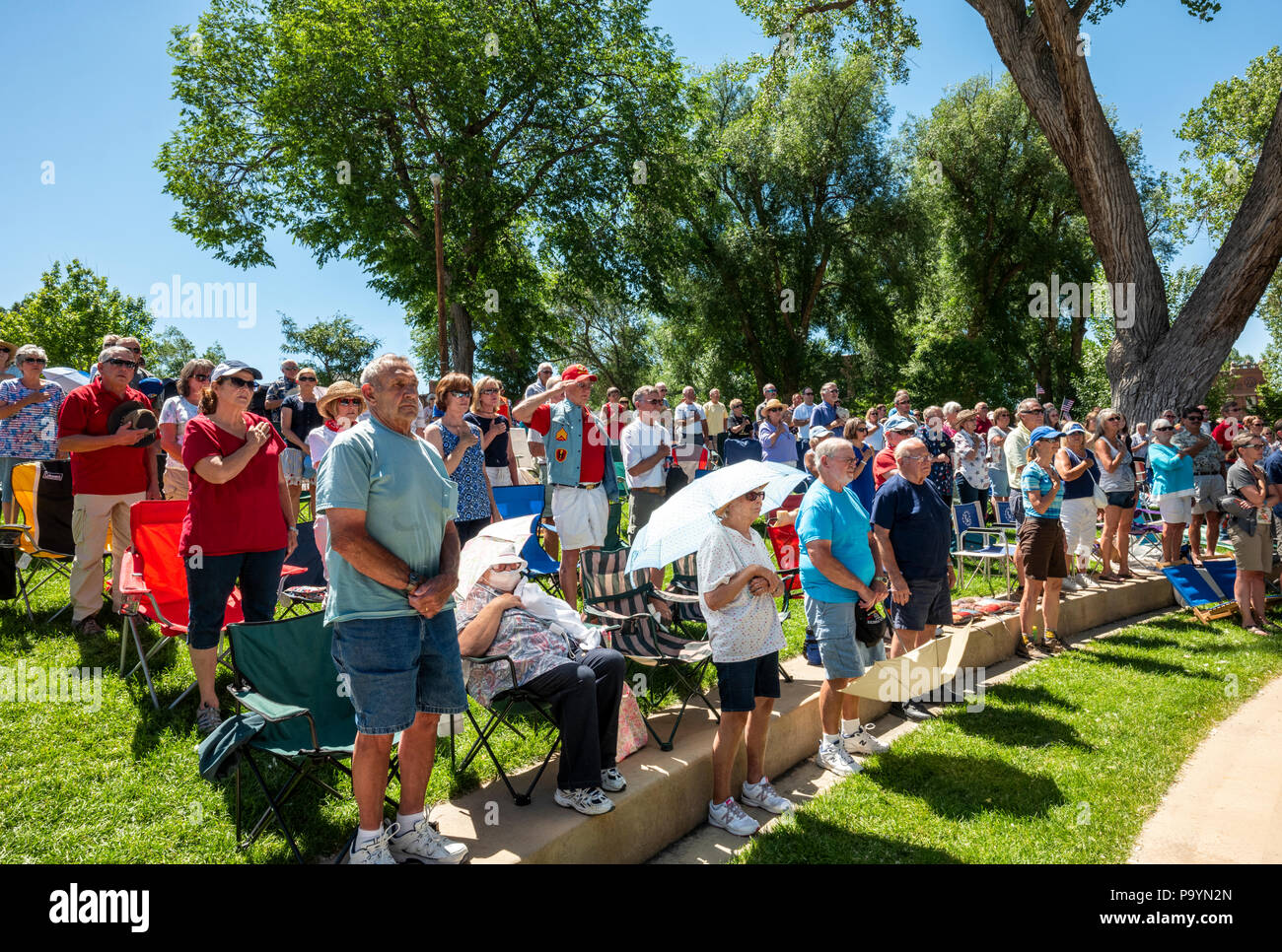 Menge steht für Nationalhymne; United States Air Force Brass Band spielt ein Viertel der Juli Konzert in der Riverside Park Band stehen, Salida, Colorado Stockfoto