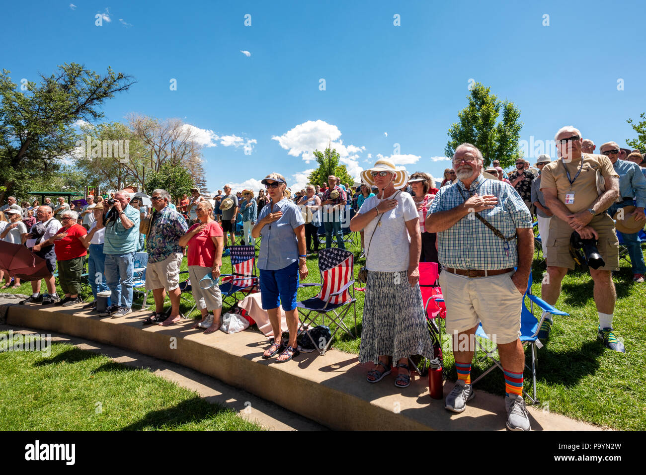 Menge steht für Nationalhymne; United States Air Force Brass Band spielt ein Viertel der Juli Konzert in der Riverside Park Band stehen, Salida, Colorado Stockfoto