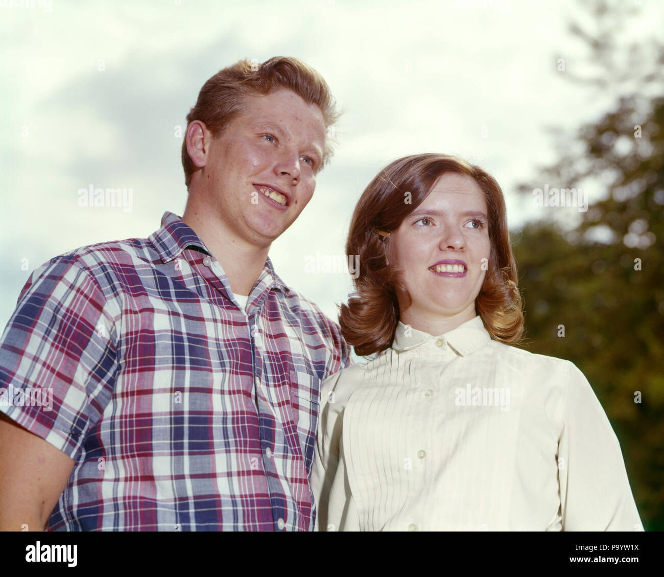 1960 lächelnde junge Teenager PAAR JUNGE TRAGEN MADRAS PLAID SHIRT GIRL weiße  Bluse - kp 1247 HAR 001 HARS FOTO KINDER KOMMUNIKATION BALANCE TEAMARBEIT  GEHEIMNIS FREUDE FREUDE LIFESTYLE FRAUEN LEBEN ZU HAUSE