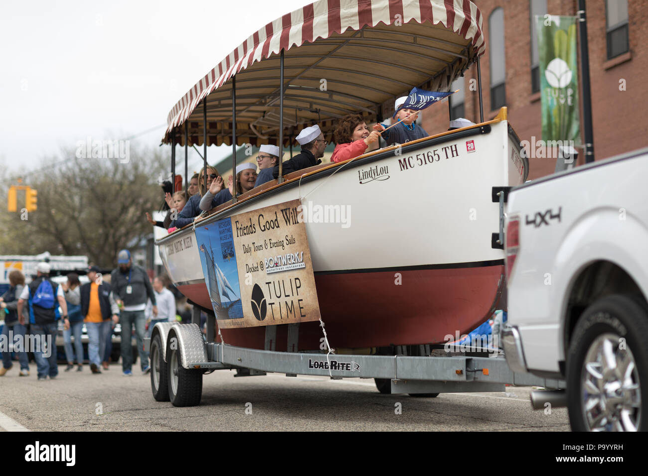 Holland, Michigan, USA - Mai 12, 2018 Leute Reiten auf einem Boot auf einem Anhänger Förderung der Michigan Maritime Museum in der Muziek Parade, während der Tul Stockfoto