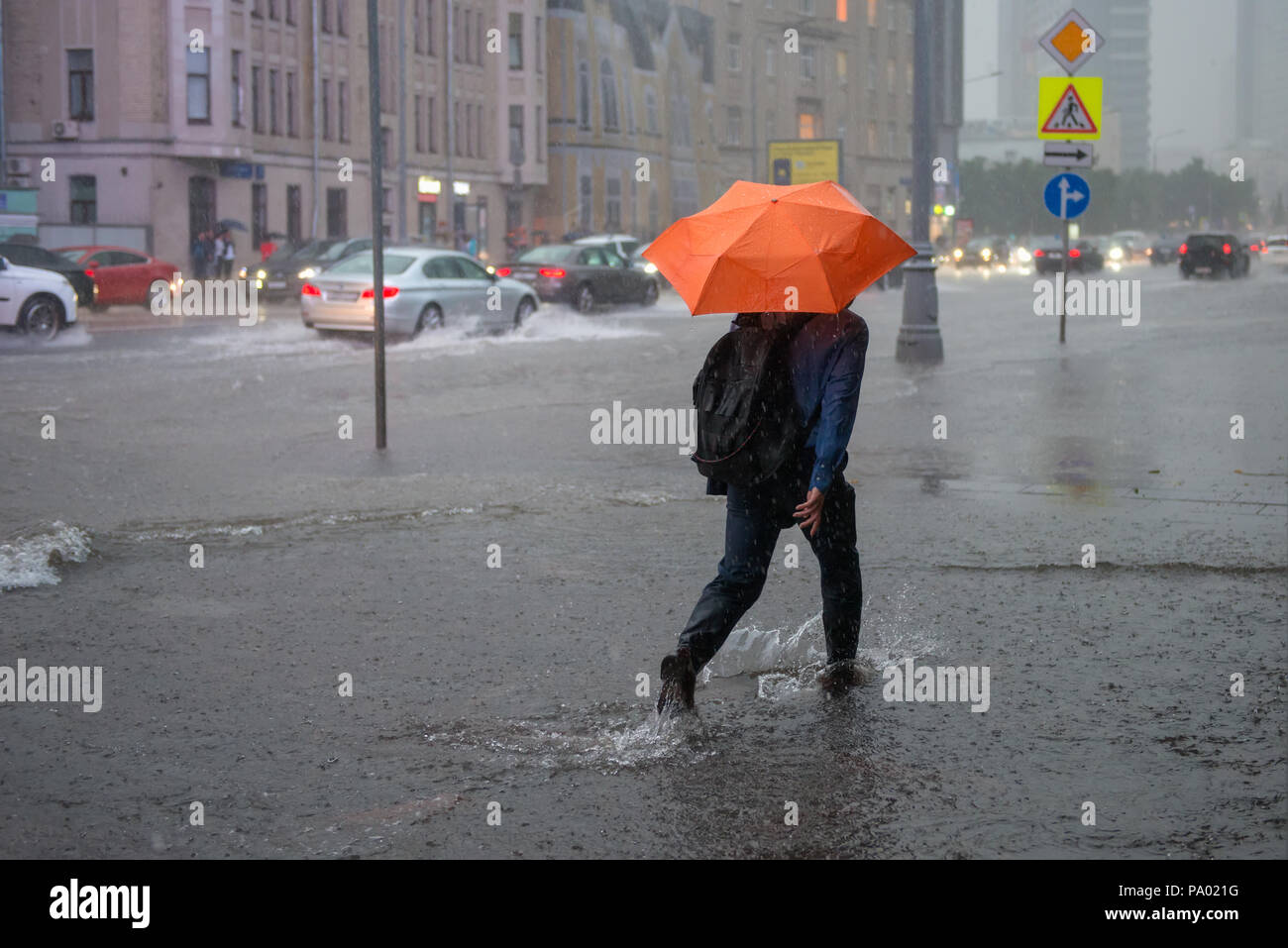 Moskau, Russland - Juli 19, 2018: schwerer Regen die Moskauer Straße Novy Arbat überflutet. Unbekannter Mann zu Fuß auf eine überflutete Straße durch die Wasserströmung unter Stockfoto