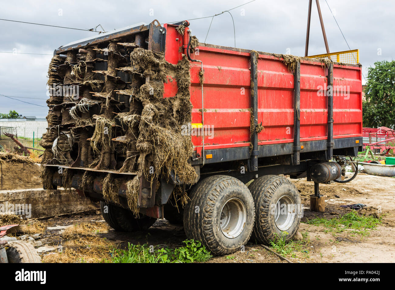 Landwirtschaftliche Maschinen auf einer Molkerei. Trailer - Distributor von organischen Düngemitteln aus Kuhmist und Stroh nach der Arbeit auf dem Feld. Allgemeine Ansicht. Stockfoto