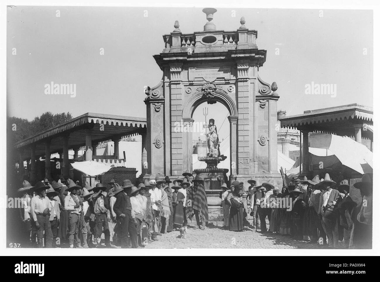 . Englisch: Neptunbrunnen, Queretaro, Mexiko, ca. 1905-1910 Foto von Neptunbrunnen, Queretaro, Mexiko, ca. 1905-1910. Eine Steinskulptur von Neptun mit Dreizack steht auf dem Brunnen, der unter einem Stein Arch, die Widmung "Para ornamento y commodidad publica Bären bauen, el M.I. Ayunamiento, año de 1797'. Eine Gruppe von mehreren Dutzend Menschen stehen an der Basis in Richtung Kamera schaut. Zwei überdachte Open-air-strukturen Winkel weg vom Arch. Rufnummer: CHS-637 Dateiname: CHS-637 Abdeckung Datum: ca. 1905/1910 Teil der Sammlung: California Historical Society Collecti Stockfoto