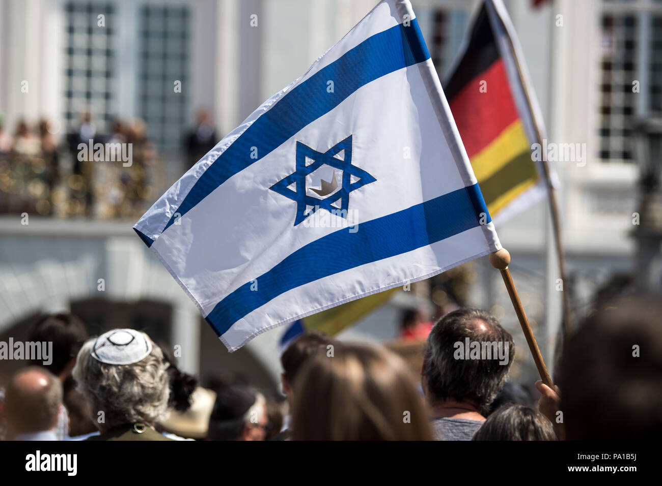 19. Juli 2018, in Deutschland, Bonn: Menschen demonstrieren gegen Antisemitismus mit israelischen und deutschen Fahnen auf dem Marktplatz. Hunderte Menschen haben gegen Antisemitismus demonstriert. Viele von ihnen trug eine Kippa. Bonn reagierte auf einen Angriff auf einen israelischen Professor mit der Kippa 'Tag'. Die alarmierte Polizei irrtümlicherweise dachte der Akademischen der Täter war und überwältigt ihn. Foto: Federico Gambarini/dpa | Verwendung weltweit Stockfoto