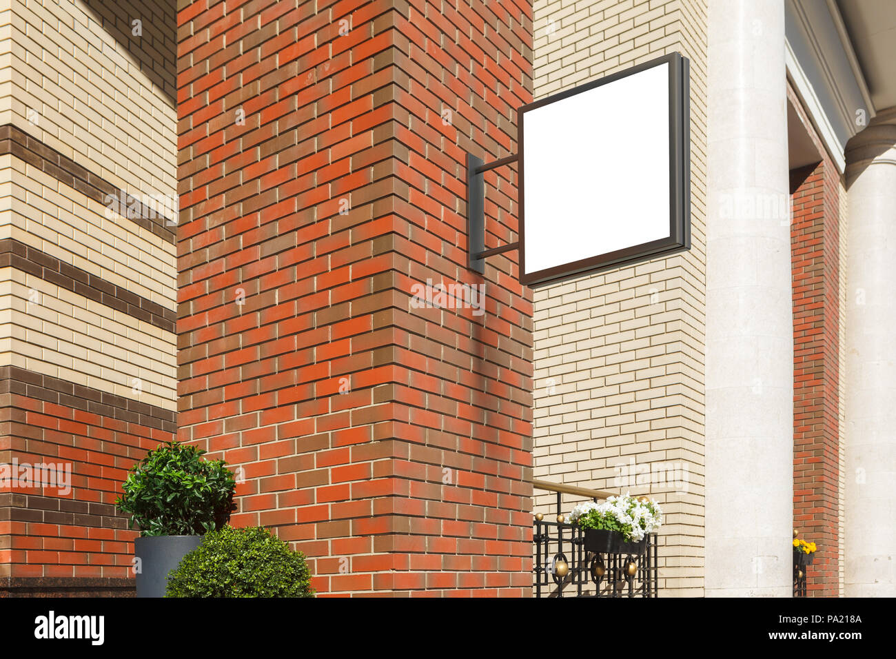 Leeres quadratisches Singboard an der Ziegelwand Stockfoto