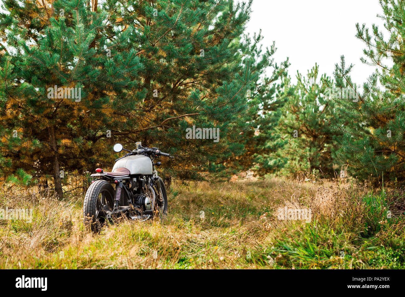 Silber handgemachte Motorrad Parkplatz auf einer Landstraße. Alles ist bereit für Spaß nach einem harten Tag im Büro. Moderne junge Unternehmer hipster Herd Stockfoto