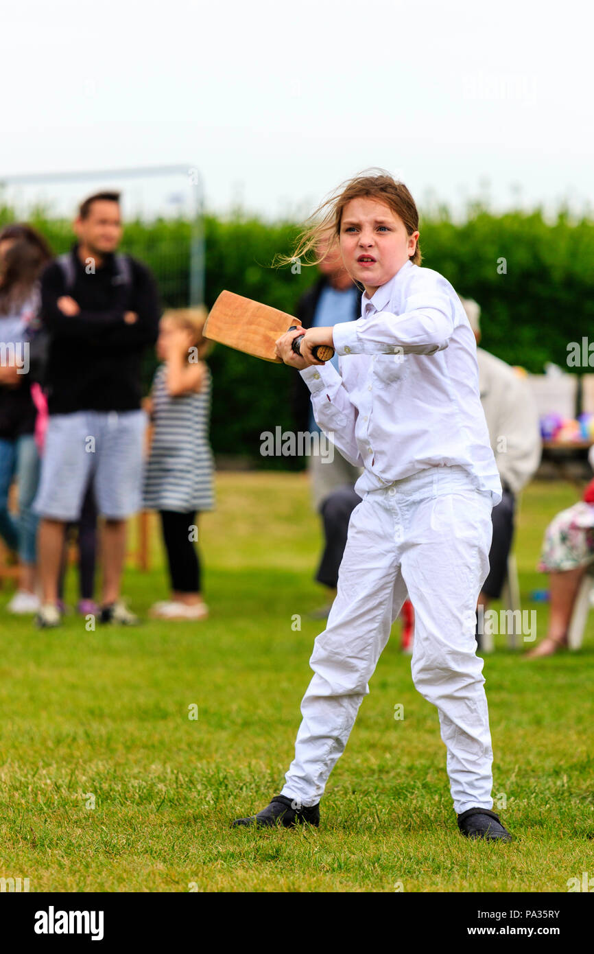 Junge Mädchen, Kind, 12-13 Jahre, Schlagen mit Cricket bat, während Sie im viktorianischen Kostüm während Cricket Match gekleidet. Broadstairs Dickens Woche Festival Stockfoto