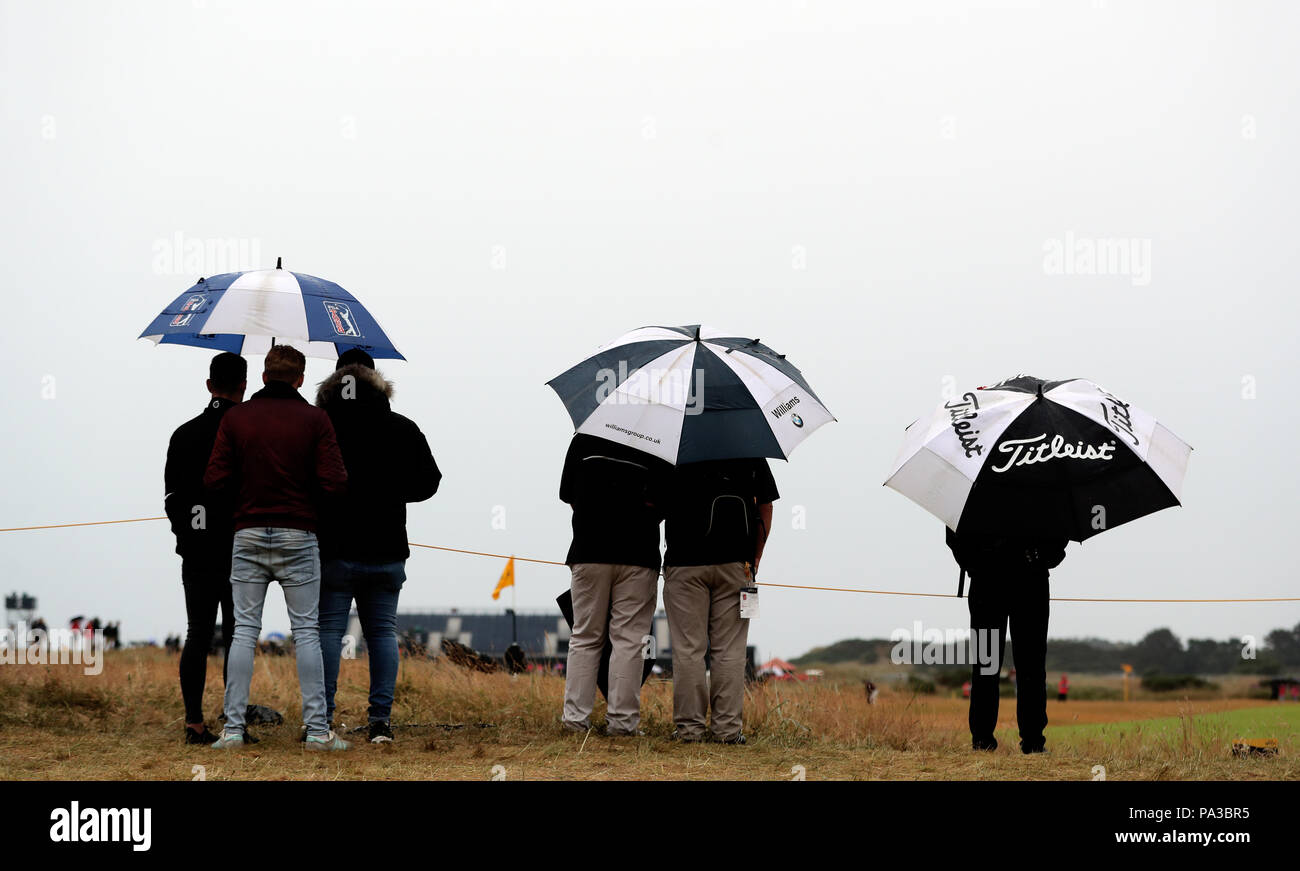 Fans Unterschlupf vor dem Regen, wie Sie die Aktion bei Tag zwei der Open Championship 2018 in Carnoustie Golf Links, Angus. Stockfoto