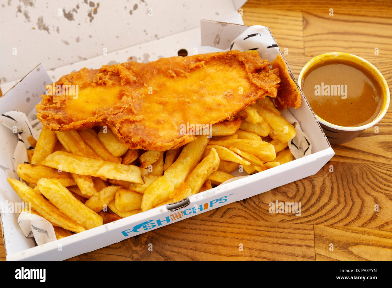 Fisch und Chips mit Currysauce in Tynemouth in England serviert. Der