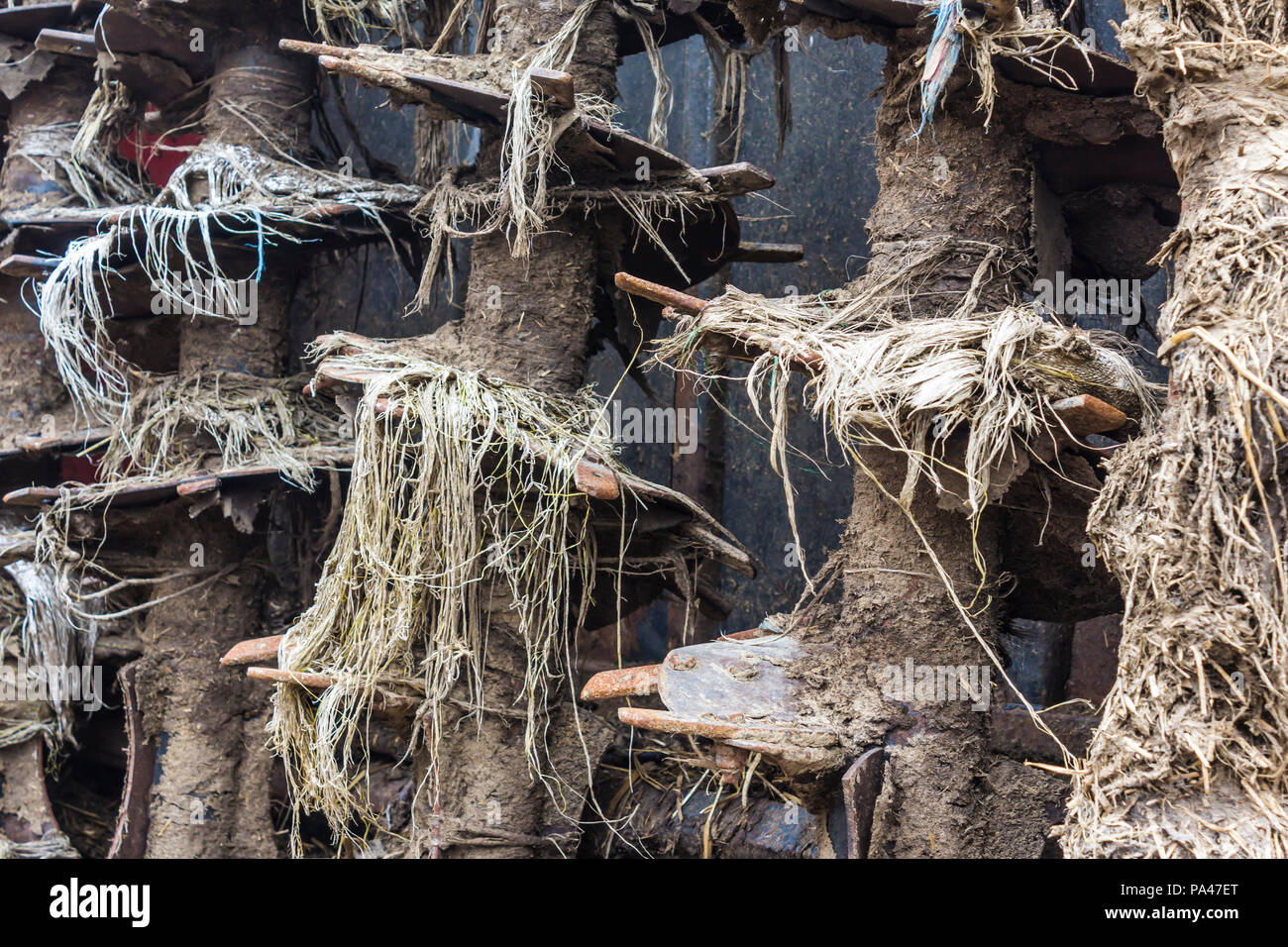 Landwirtschaftliche Maschinen auf dem Bauernhof. Der Mechanismus auf dem Anhänger - Vertrieb von Düngemitteln aus Kuhmist und Stroh. Nach der Arbeit auf dem Feld. Close-up. Stockfoto