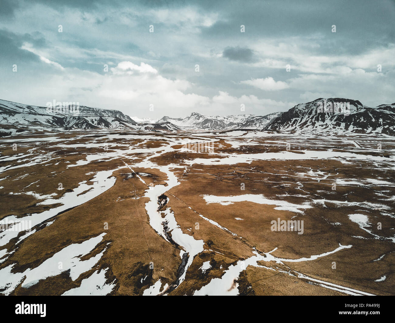 Island Luftaufnahme Landschaft mit Schnee und Wolken-, Street- und Gelbes und grünes Gras Stockfoto