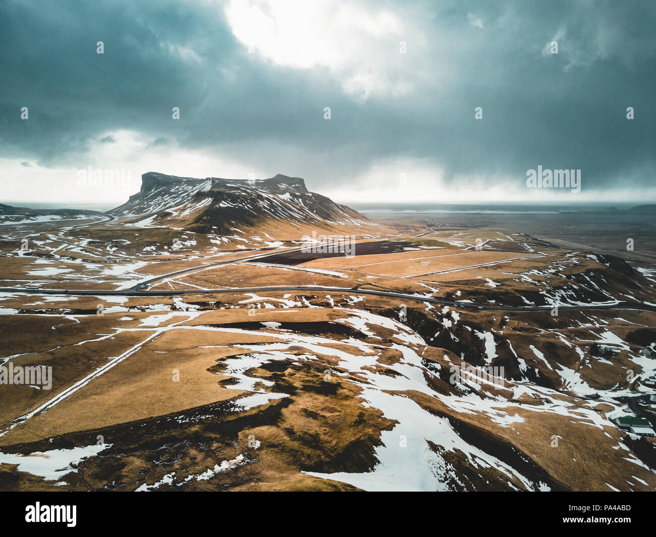 Island Luftaufnahme Landschaft mit Schnee und Wolken-, Street- und Gelbes und grünes Gras Stockfoto