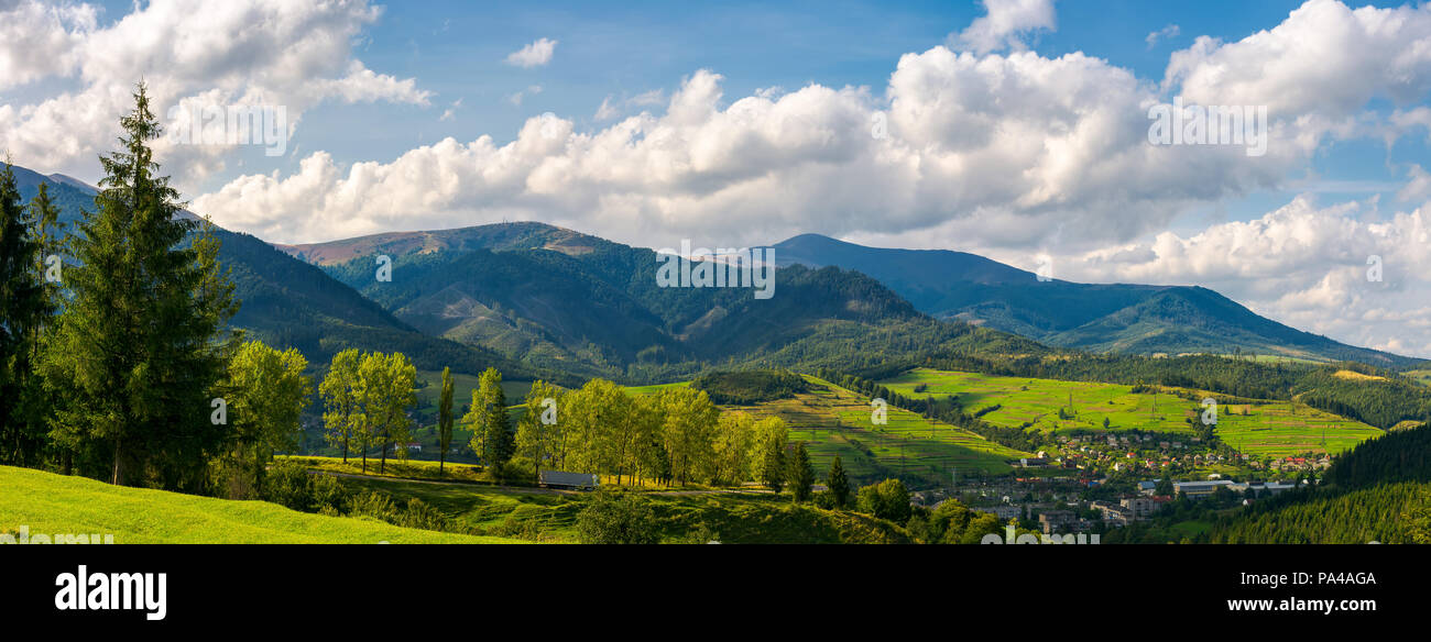 Panorama der bergigen Stadtgebiet. schöne Landschaft Landschaft im frühen Herbst Bäume entlang der Straße den Hügel hinunter. Dorf unten im Tal und c Stockfoto