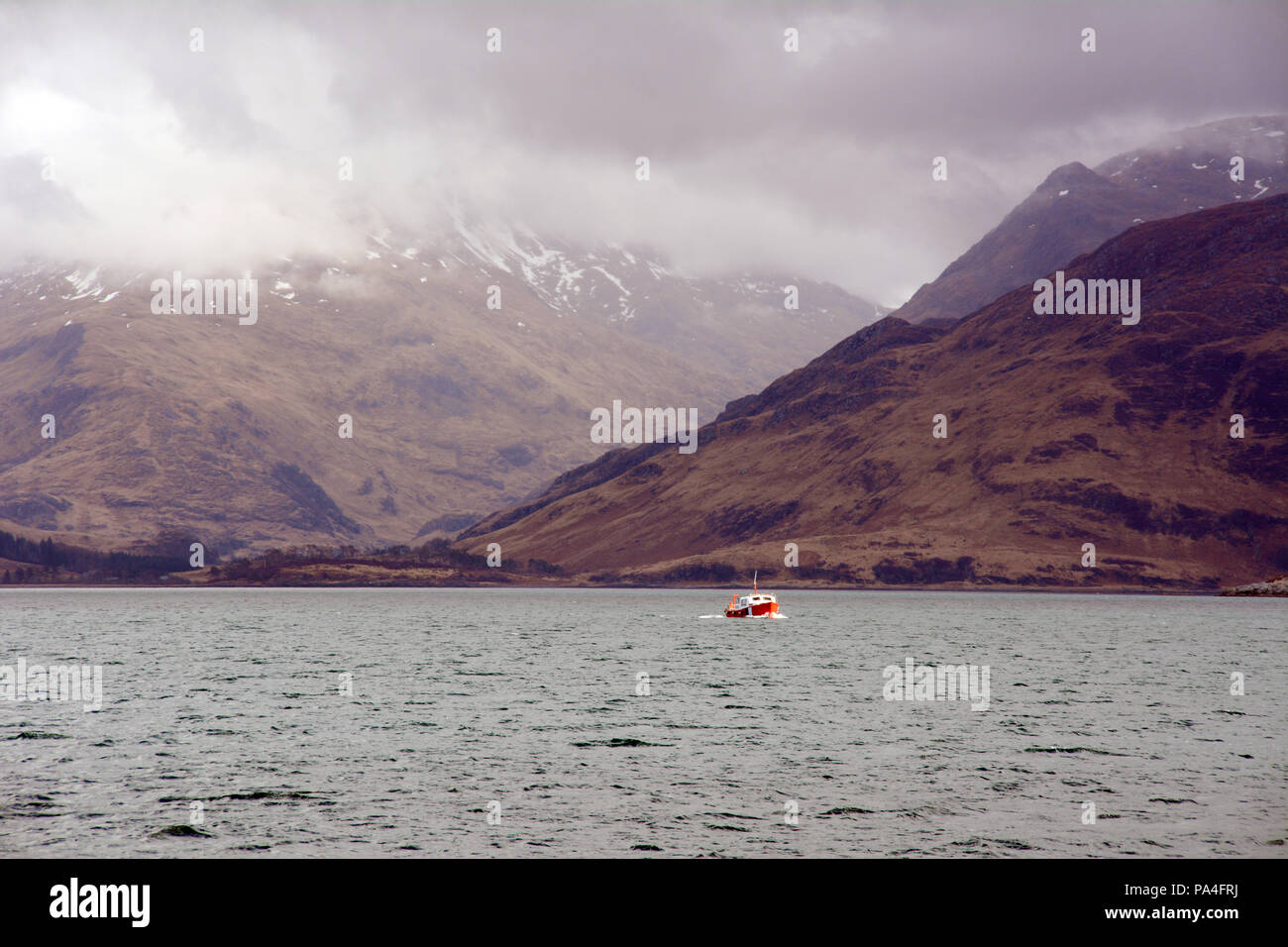 In den Bergen und Nebel über einem Boot im Loch Nevis vor der Küste der Halbinsel Knoydart, Northwest Highlands, Schottland, Großbritannien. Stockfoto