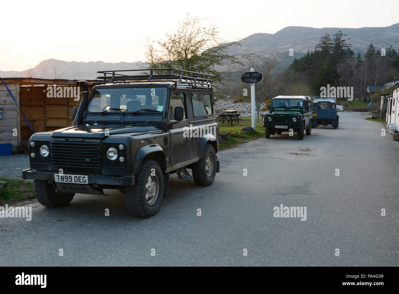 Eine Reihe von drei geparkte Land Rover Defender Fahrzeuge entlang der Hauptstraße in der Stadt von Inverie, auf der Halbinsel Knoydart, Schottland, Vereinigtes Königreich. Stockfoto