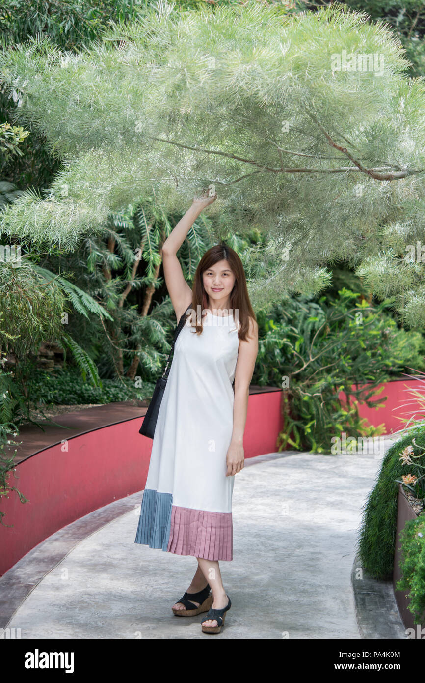 Portrait von süßen Jungen asiatischen Frauen mit weißen Kleid und in der Blüte Kuppel der Garten an der Bucht, Singapur - ein Mann aus Green House posieren. Stockfoto