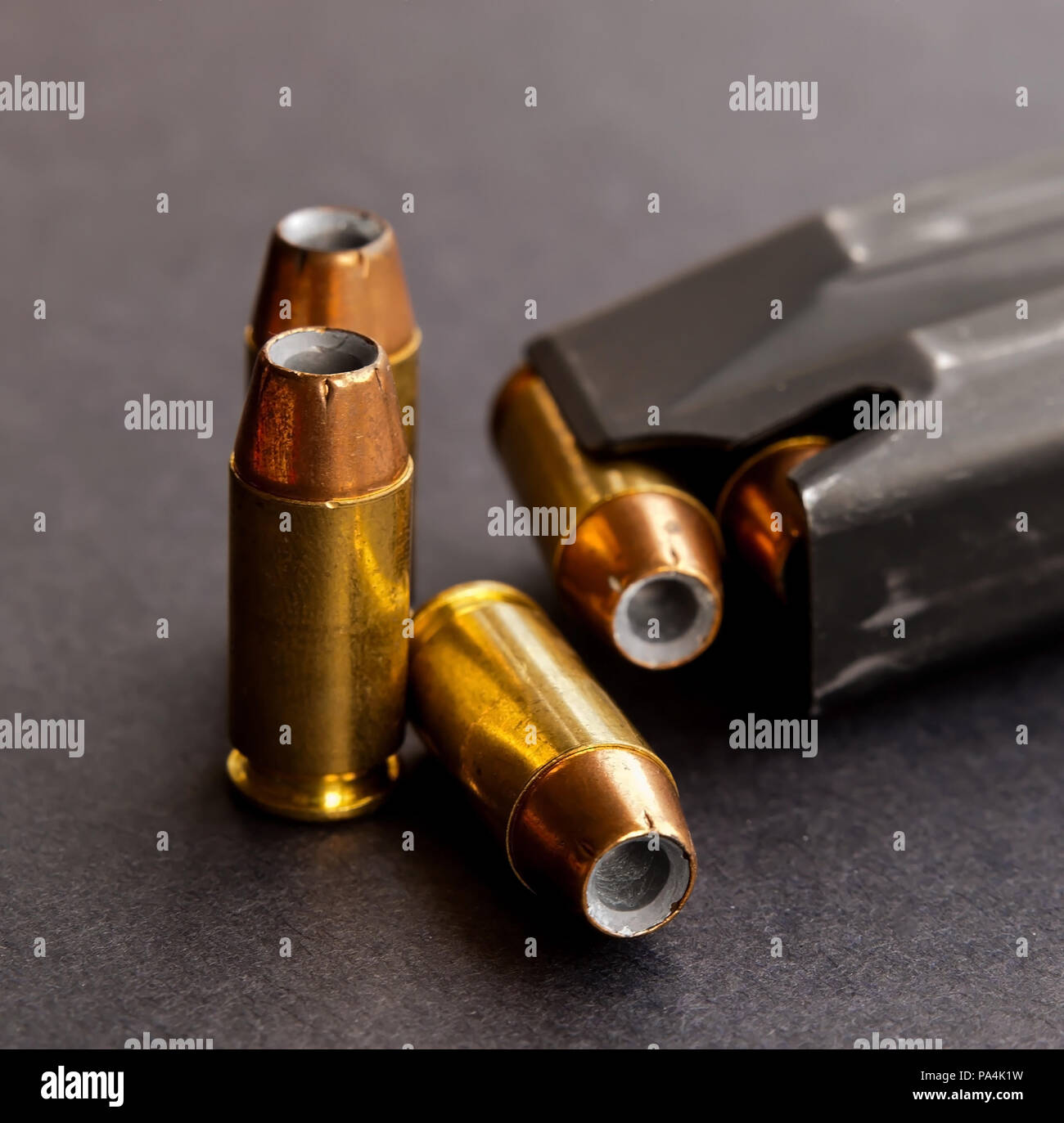Drei hohlen Punkt Punkte neben eine geladene Pistole Magazin auf schwarzem Hintergrund Stockfoto