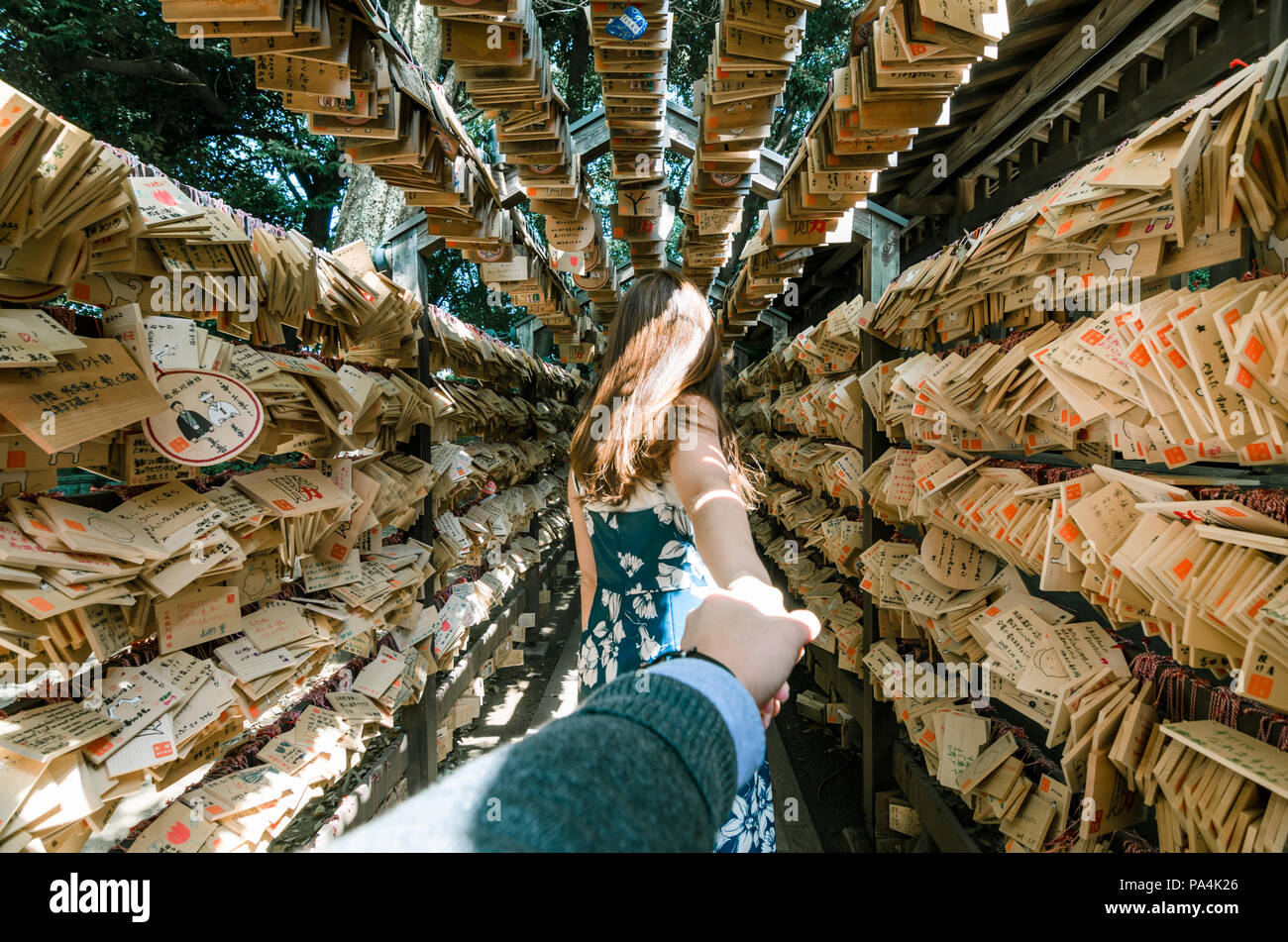 Portrait von schönen Frauen ihren Freund Hand, während ihm die zur tunne von Ema am Hikawa Schrein, ein Heiligtum berühmt für Spiel machen. Stockfoto