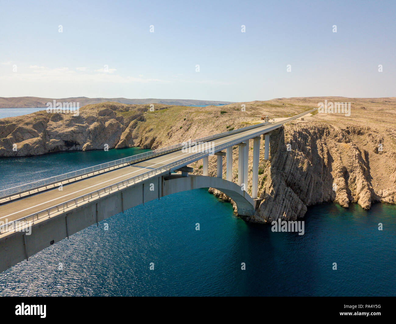 Luftaufnahme der Brücke von der Insel Pag, Kroatien, Straßen und der kroatischen Küste. Klippe mit Blick auf das Meer. Autos über die Brücke von oben gesehen Stockfoto