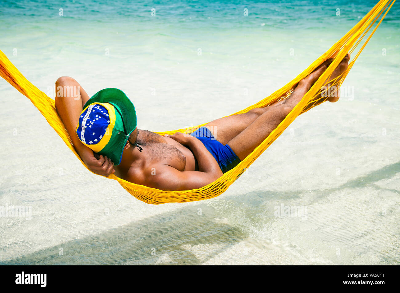 Brasilianischen Mann in sunga Badeanzug und Brasilien Flagge hat sich im Seaside Beach Hängematte in Brasilien. Stockfoto