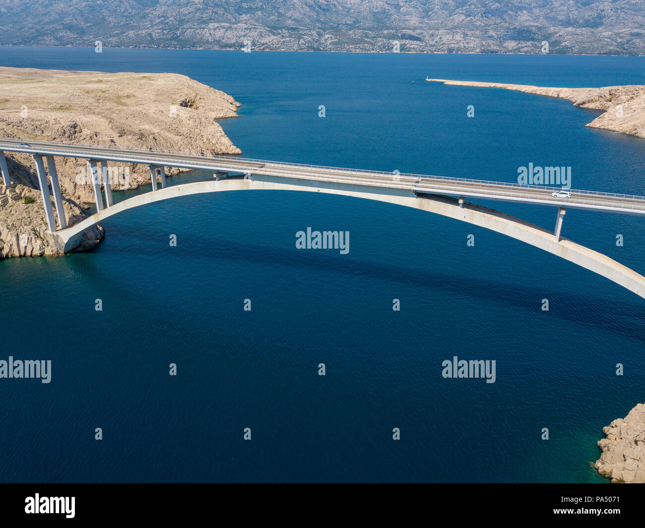 Luftaufnahme der Brücke von der Insel Pag, Kroatien, Straßen und der kroatischen Küste. Klippe mit Blick auf das Meer. Autos über die Brücke von oben gesehen Stockfoto