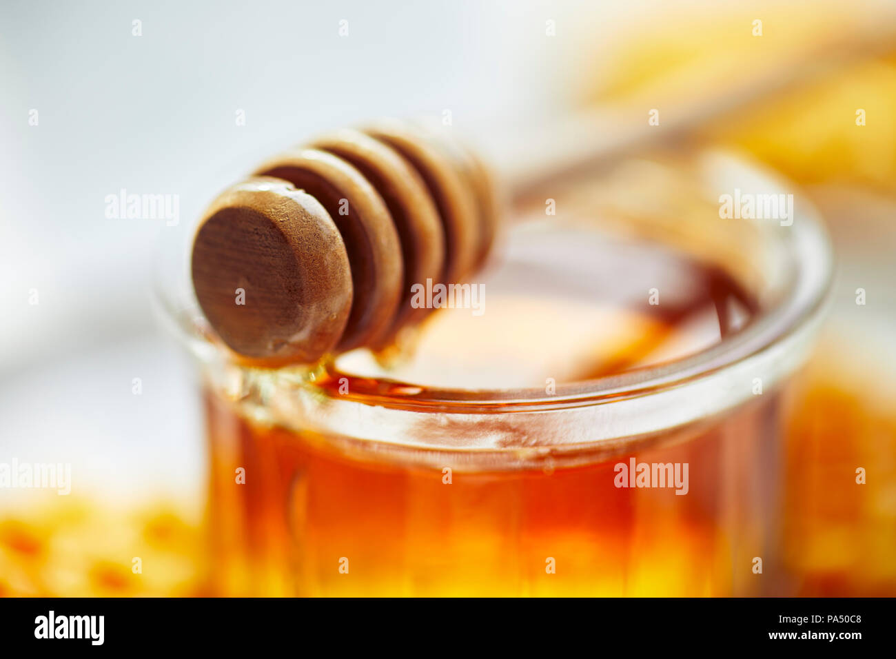 Honig in einem Glas mit Holz- Pendelarm Stockfoto