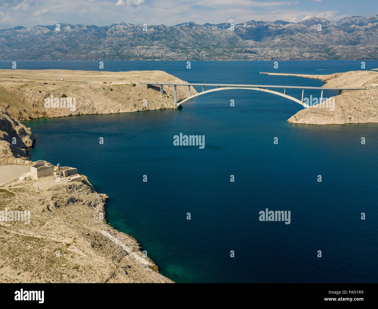 Luftaufnahme der Brücke von der Insel Pag, Kroatien. Die Ruinen der alten Festung Fortica auf der Insel Pag, Kroatien. Autos über die Brücke Stockfoto