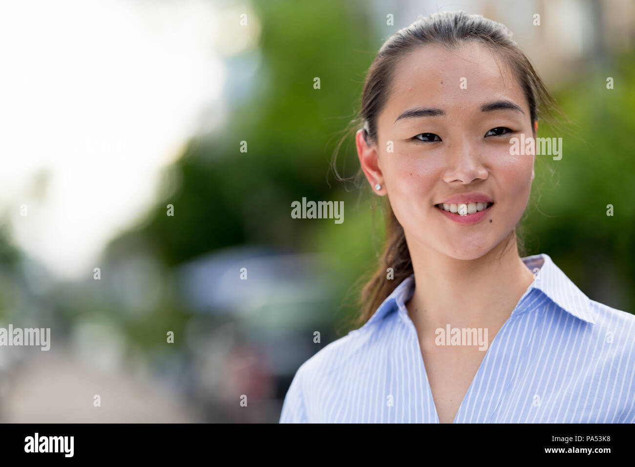 Junge schöne asiatische Geschäftsfrau im Freien Stockfoto