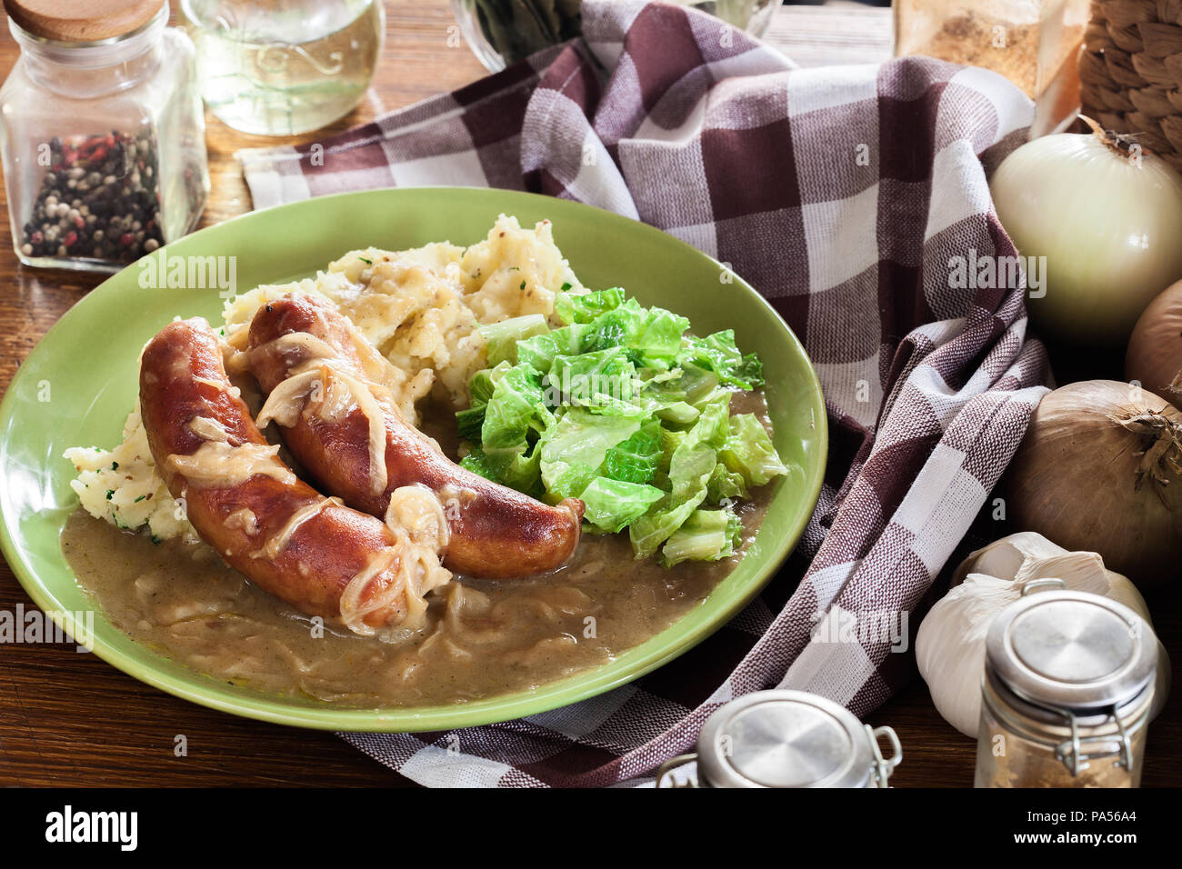 Würstchen mit Kartoffelbrei. Gebackene Wurst im Onion gravy mit Kartoffelpüree und Rotkohl serviert. Stockfoto