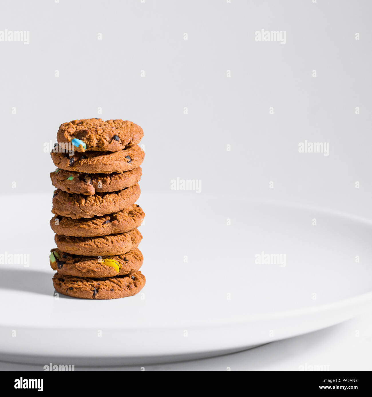 Choc Chip Cookies Smarties auf einem weißen Teller gestapelt. Stockfoto