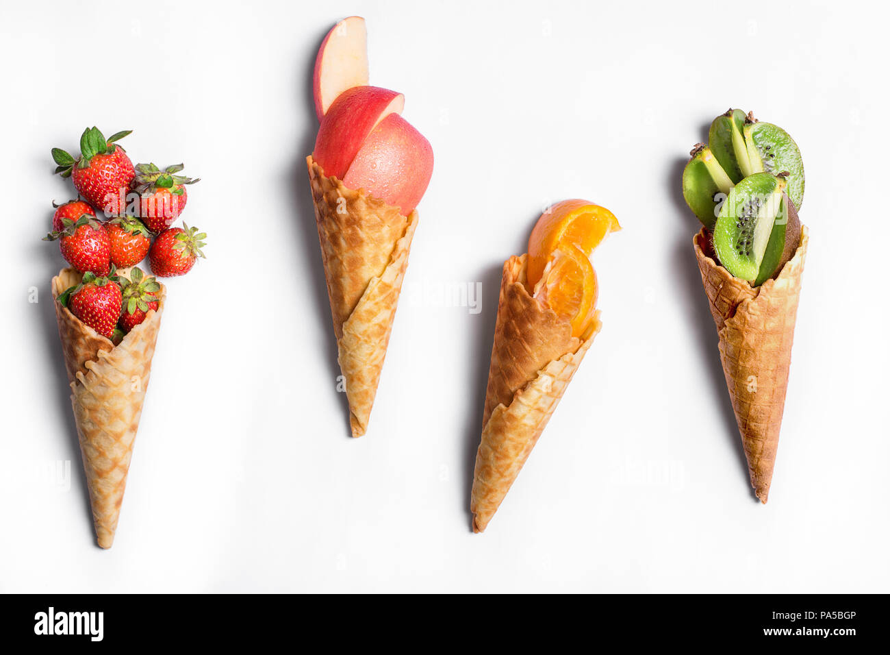 Obst im Waffle Kegel auf weißem Hintergrund - gesunde Eis Optionen. Stockfoto