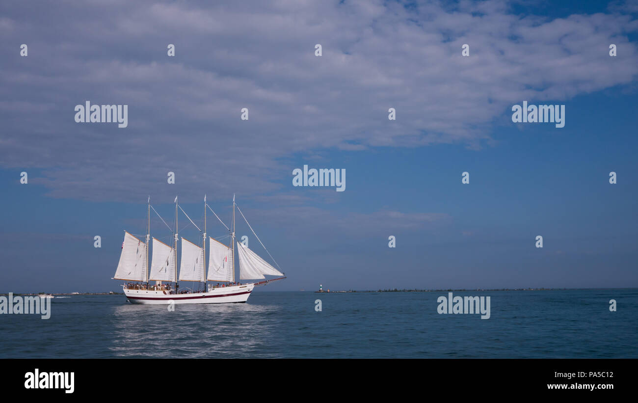 Vier Dreimaster, weiße Segel Schiff auf dem Michigan See segeln am frühen Abend an den ruhigen blauen Wasser und blauer Himmel. Stockfoto