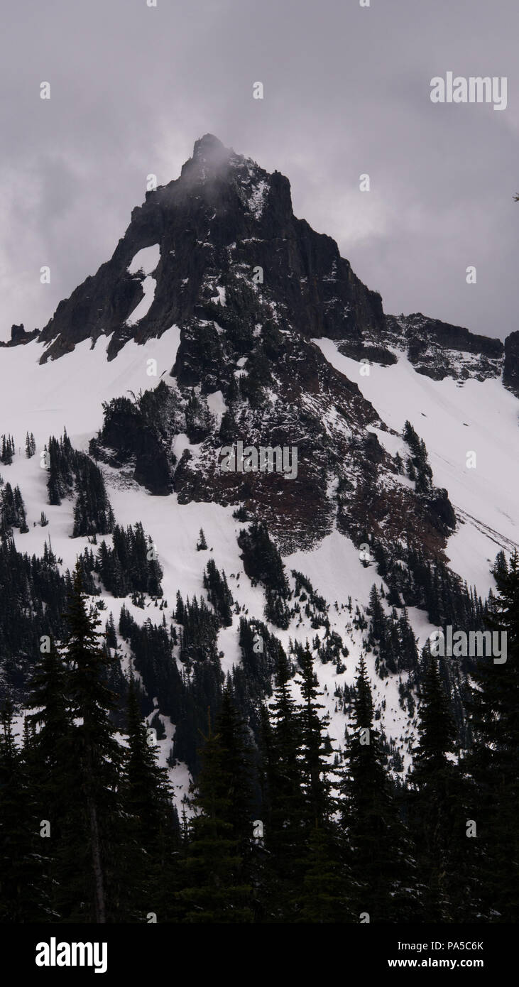 Schneebedeckte Berggipfel in Mt Rainier National Park im Sommer. Schnee auf Flanken von Peak mit Moody Wolken in der Nähe der Gipfel. Stockfoto