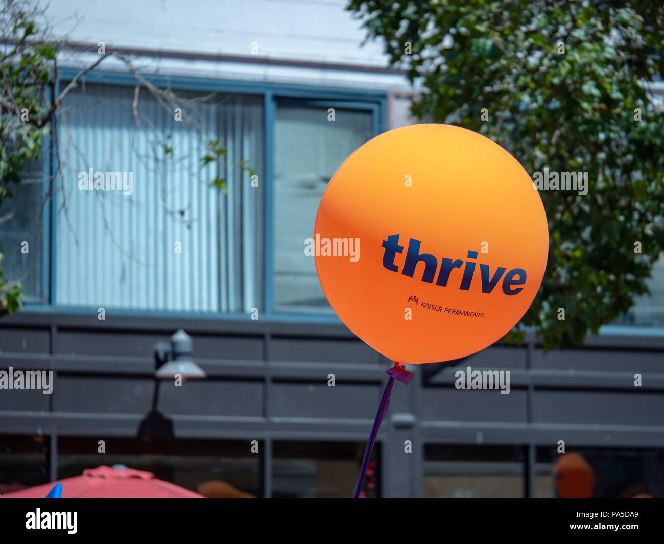 Orange Kaiser Permanente gedeihen ballon Fliegen in einem städtischen Gebiet Stockfoto