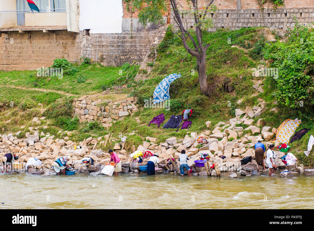 ANTANANARIVO, MADAGASKAR - Juni 28, 2011: Unbekannter Madagaskar Menschen saubere und trockene Kleidung in einem Fluss. Menschen in Madagaskar Leiden der Armut durch Stockfoto