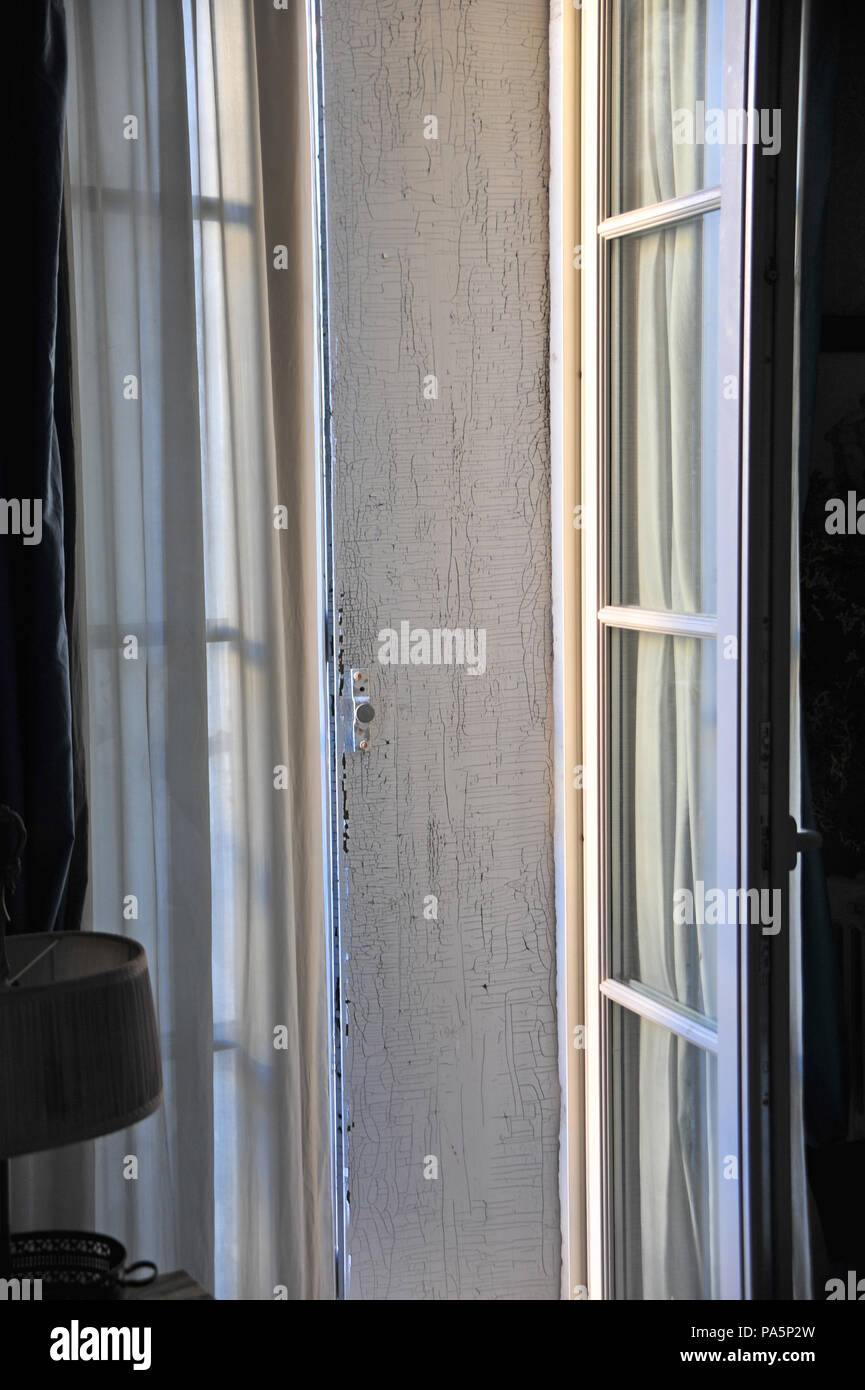 Am frühen Morgen aus einem offenen Fenster und Fensterläden, die zu den Außen Balkon in einem großen französischen Dorf Haus suchen Stockfoto