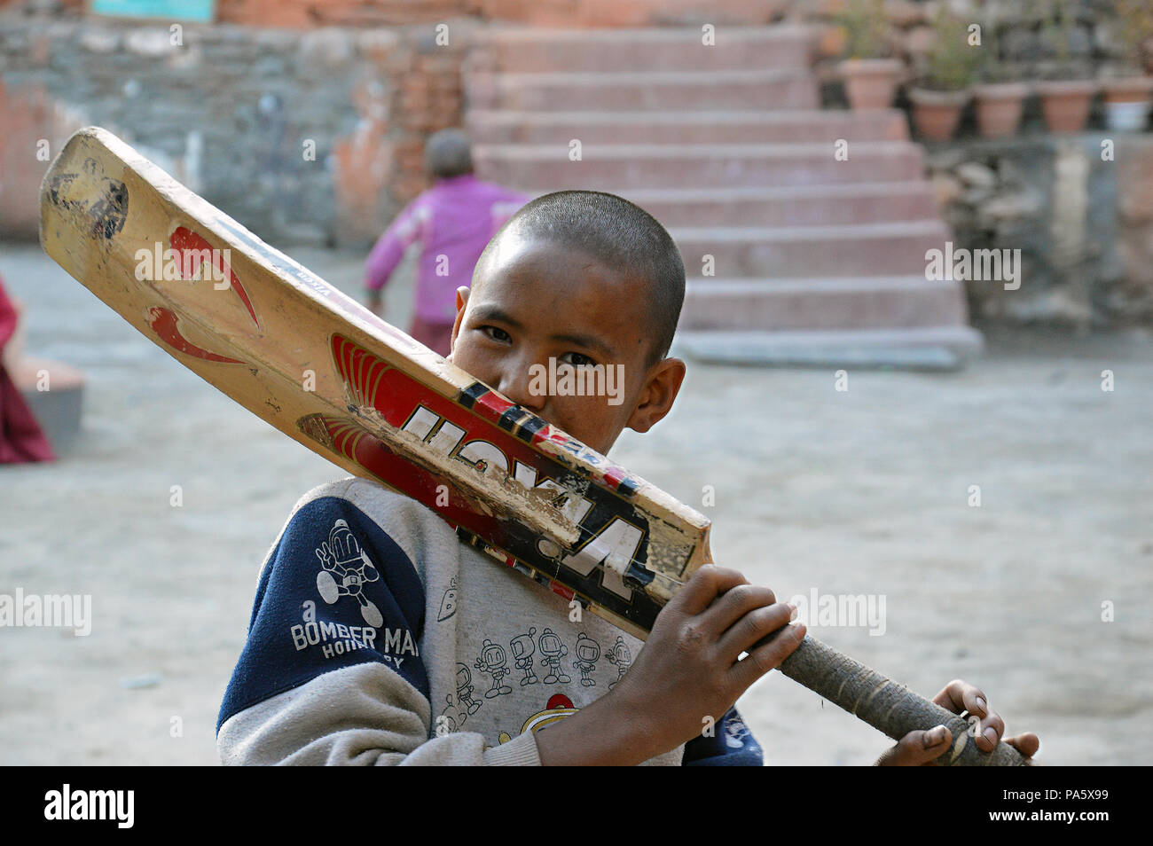 Einen jungen Küssen eine alte Kricketschläger an einer Schule in Kagbeni, Mustang, Nepal. 11.09.2014. Stockfoto