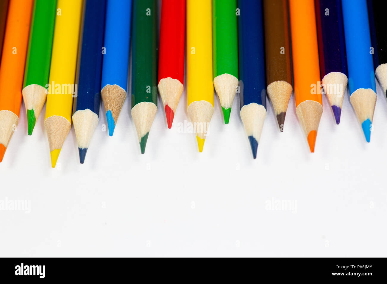 Buntstifte aufgereiht in einer Reihe gegen einen weißen Hintergrund. Stockfoto