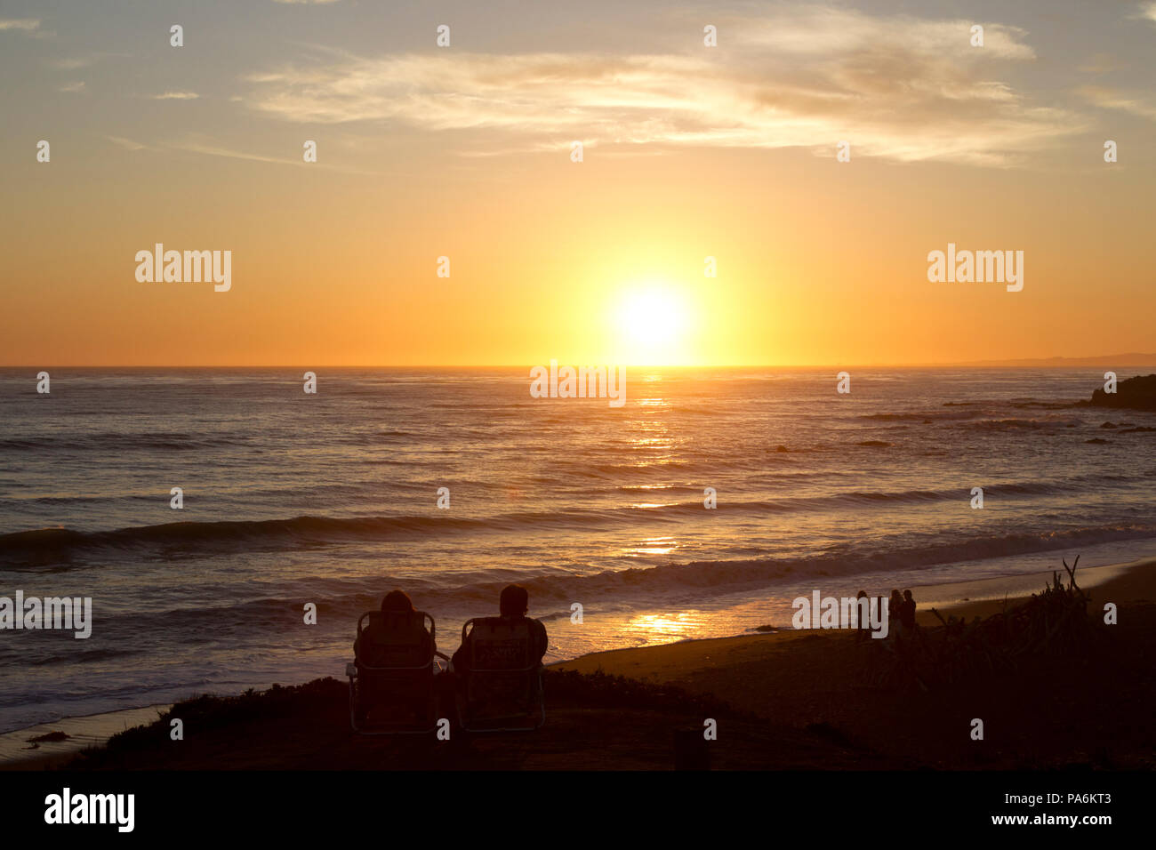 Zwei Leute beobachten Sonnenuntergang über dem Pazifischen Ozean Stockfoto