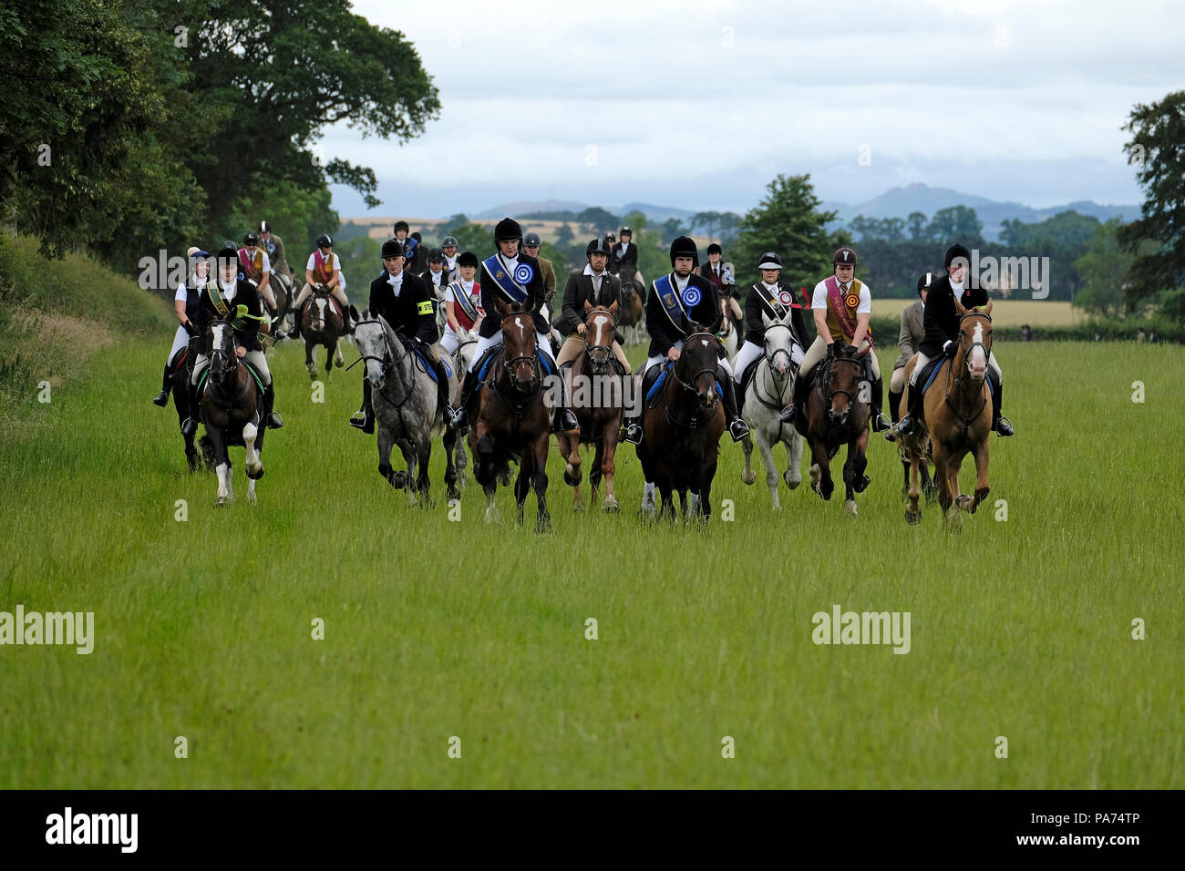 KELSO, Schottland - Juli 21: Kelso Civic Woche - yetholm Rideout; die Schulleiter führen einen Galopp über offene Felder in der Nähe von Kelso zu Beginn der Yetholm Rideout während der KELSO Civic Woche, ein jährliches Festival, Teil der schottischen Grenze gemeinsame Reiten Saison. Am 21. Juli 2018 in Kelso. Bild: Rob Grau/Alamy leben Nachrichten Stockfoto