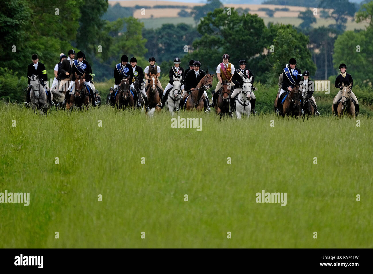 KELSO, Schottland - Juli 21: Kelso Civic Woche - yetholm Rideout; die Schulleiter führen einen Galopp über offene Felder in der Nähe von Kelso zu Beginn der Yetholm Rideout während der KELSO Civic Woche, ein jährliches Festival, Teil der schottischen Grenze gemeinsame Reiten Saison. Am 21. Juli 2018 in Kelso. Bild: Rob Grau/Alamy leben Nachrichten Stockfoto