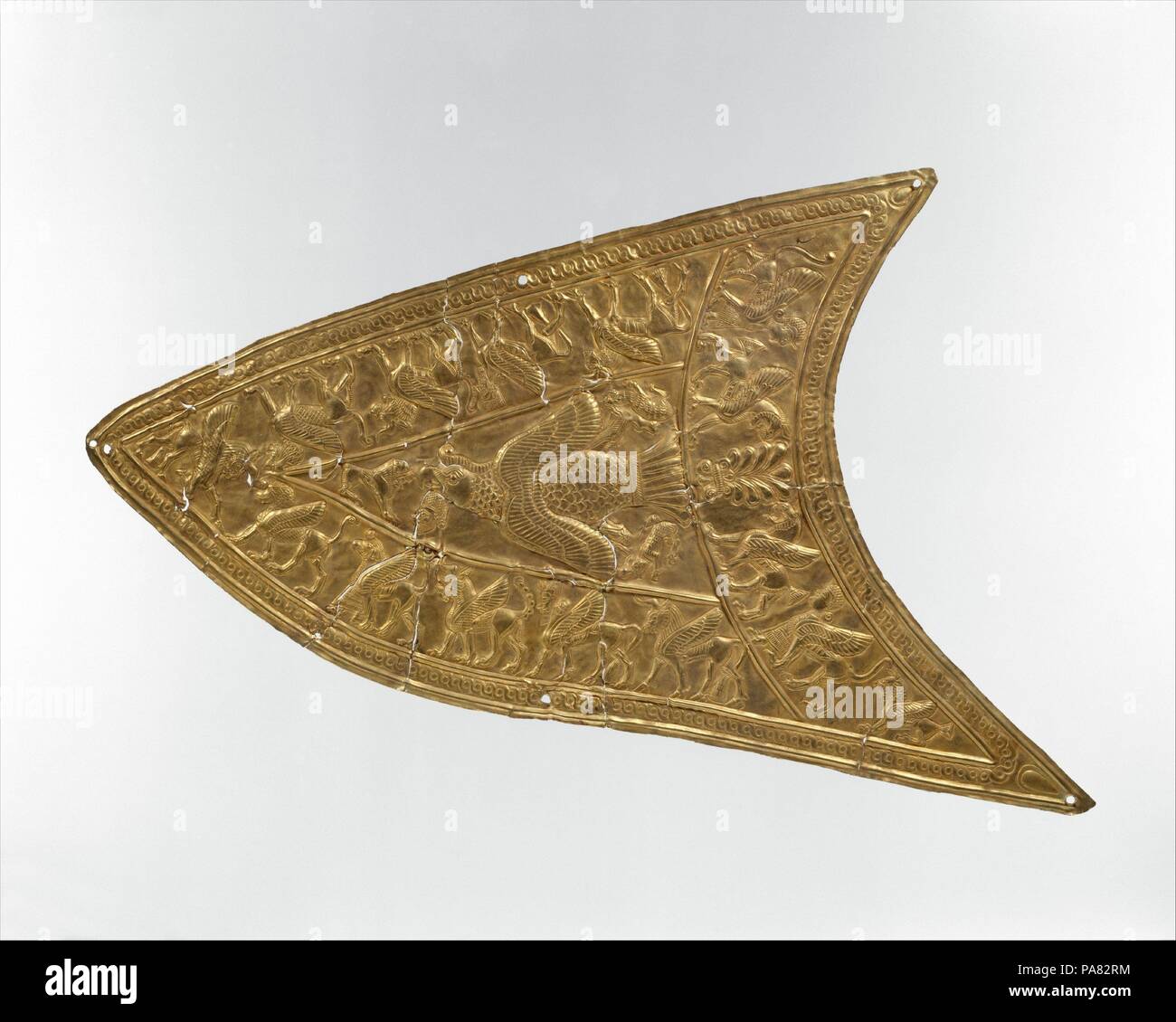 Plakette mit einem Raubvogel und Geflügelte Tiere. Kultur: Iran. Abmessungen: 5.12 x 8.86 in. (13 x 22,5 cm). Datum: Ca. 8. bis 7. Jahrhundert v. Chr.. Dieses fein gearbeiteten Plakette in die Technik der repoussé eingerichtet ist, die aus einer Anzahl von Fragmenten zu verbinden. In der Mitte ein Griffin Vogel im Flug gezeigt wird, seinen Körper und Flügeln dargestellt von oben gesehen. In seinen Krallen der Vogel greift zwei Kreaturen, während unter seinen Schnabel ist der Kopf eines bärtigen Mannes. Ein Löwe mit seinen Mund offen konfrontiert den Vogel. Drei Bands mit Composite Kreaturen wie den geflügelten Löwen und Bullen schmücken den Umfang des Objekts. Ein gu Stockfoto