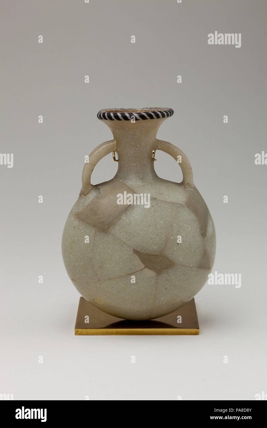 Flasche. Abmessungen: H 13. 2 cm (5 13/16 in.), Diam. 9,6 cm (3 3/4 in.). Dynastie: Dynasty 19-20. Datum: Ca. 1295-1070 v. Chr.. Ägyptische Glasmacherkunst, die ein hohes Maß an Virtuosität in späten Dynastie 18 erreicht hatte, setzte sich in den Ramessidischer Zeit praktiziert werden, aber die Qualität sowie Quantität der it-Produktion fiel weg scharf im Dynasty 20. Das Design der Flasche ist charakteristisch für seine Zeit als Schwarzweiß mit nur einem "Seil" von Glasmalereien Stangen in Kontrastfarbe an der Felge befestigt wird. Museum: Metropolitan Museum of Art, New York, USA. Stockfoto