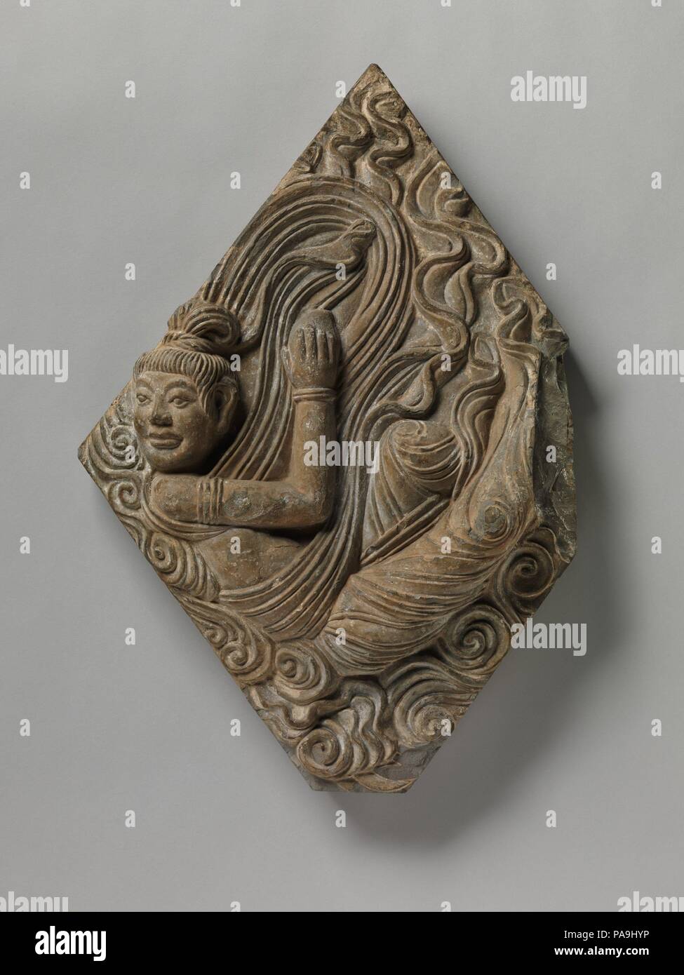 Fliegende Himmelskörper Apsara (Feitian). Kultur: China. Abmessungen: H.26 cm. (67,9 cm); W. 16 3/4 in. (42,5 cm); D.4 3/4 in. (12,1 cm); Wt. 30,3 kg (13,7 kg). Datum: 7. Himmlische Begleiter sowohl für Buddhistische und hinduistische Gottheiten in Südasien, apsaras sind auch häufig in Ostasien buddhistische Kunst. Dieses rautenförmigen Fliesen kann das Äußere der Pagode des Xiuding Tempel in der Nähe von Anyang in der Provinz Henan eingerichtet haben, dargestellt. Museum: Metropolitan Museum of Art, New York, USA. Stockfoto