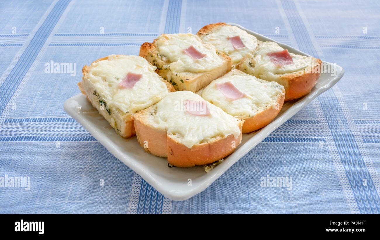Frische hausgemachte Brot mit Knoblauch, Käse und Kräutern auf Platte Stockfoto