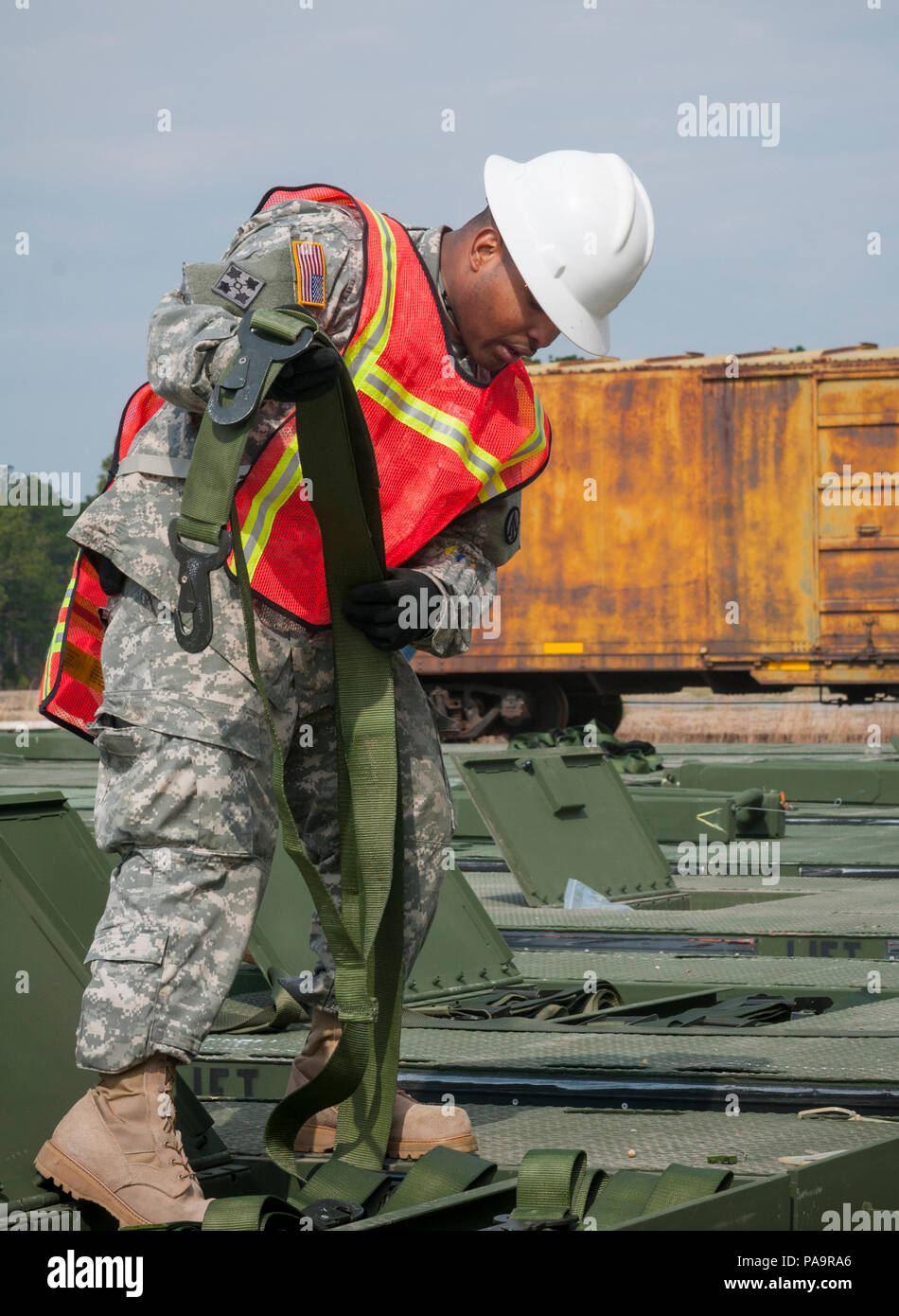 Staff Sgt. Juan Herrera, ein cargo Fachmann mit der 1174Th Bereitstellung und Verteilung Bataillon am Fort Totten, N.Y., prüft die Gurte zur Ladungssicherung während des Transmariner Übung in Military Ocean Terminal Sunny Point, N.C. verwendet Während Transmariner, Army Reserve Soldaten Empfangen, Prüfen, Verpacken und bereit, Munition für das Laden an Bord der Schiffe von März 13 bis Mai 21. (U.S. Armee Foto von SPC. Gregory Lydick/freigegeben) Stockfoto