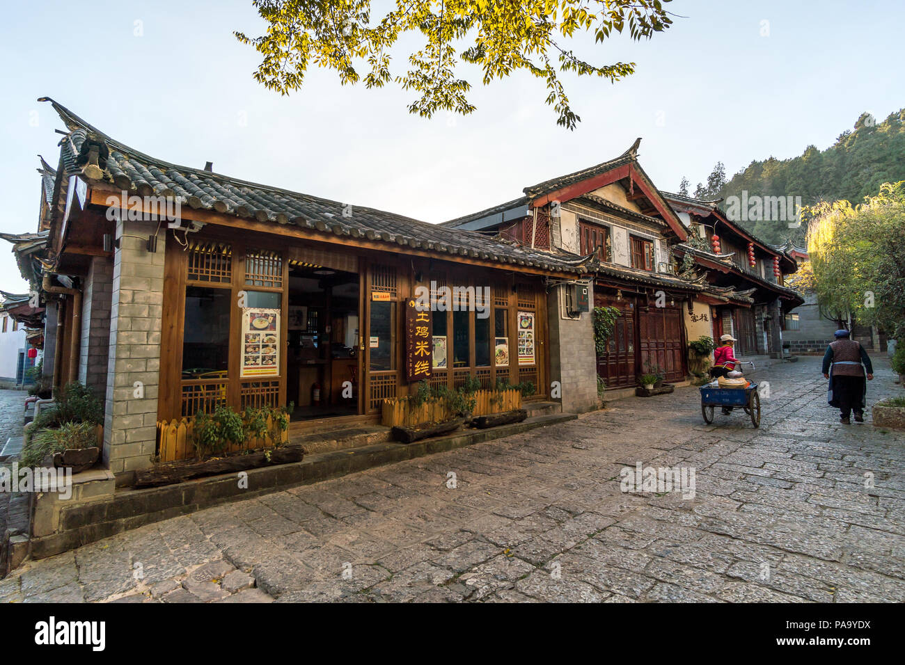 Malerische Straße in der Altstadt von Lijiang, Provinz Yunnan, China. Holz- Fassaden der traditionellen chinesischen Häusern. Die Altstadt von Lijiang ist ein beliebter t Stockfoto